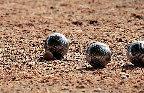 Photo de 3 boules sur un terrain de pétanque
