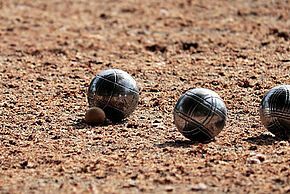 Photo de 3 boules sur un terrain de pétanque